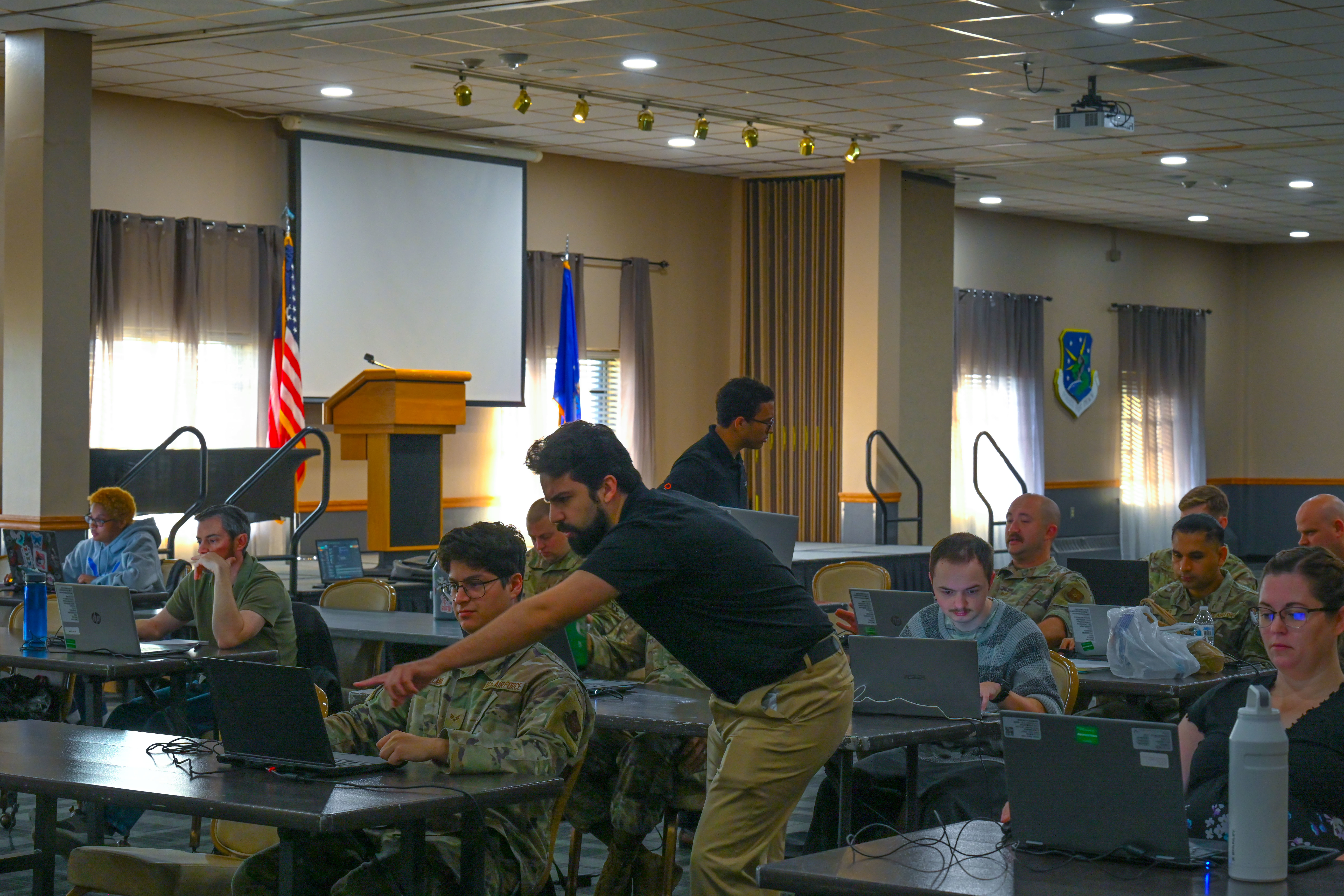 Invoke bootcamp in session — instructor working with Airmen at laptops